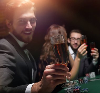 poker oyuncusu bir kadeh şarap ile