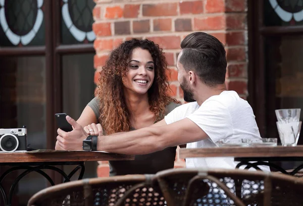 Porträt eines jungen Paares, das sich auf eine Caféterrasse setzt — Stockfoto