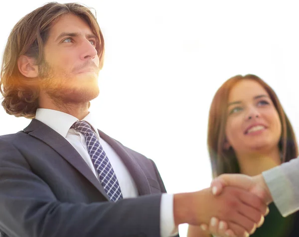 Businesspeople  shaking hands against room with large window loo — Stock Photo, Image
