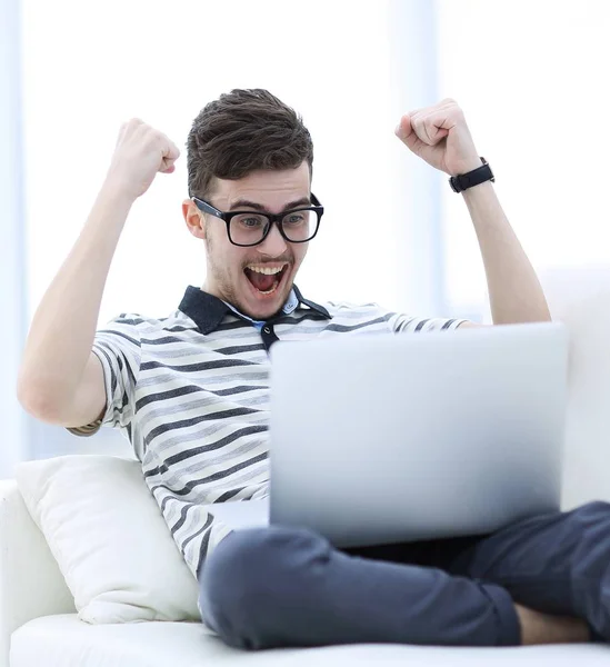 Uomo felice con computer portatile seduto sul divano — Foto Stock