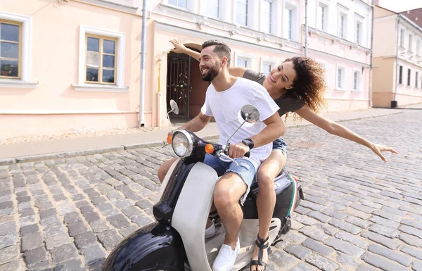 Felice giovane coppia divertirsi su uno scooter — Foto Stock