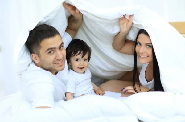 Familias con niños en la cama bajo una manta —  Fotos de Stock