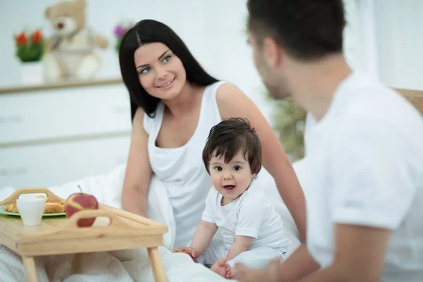 Familia tomando el desayuno en la cama en el dormitorio —  Fotos de Stock