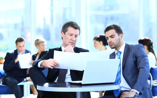 Affärspartners diskuterar ett nytt projekt, sitter i lobbyn på kontoret. — Stockfoto