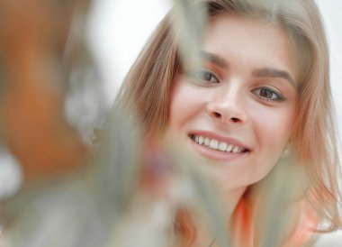 kadın yüzü bulanık arka plan üzerinde gülümseyen portresi.