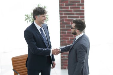 İki işadamı ofiste el sıkışıyor.