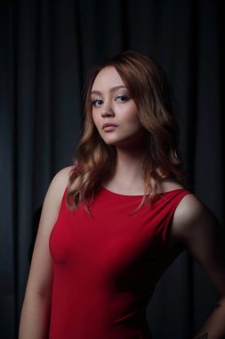Siyah bir arka plan üzerinde poz Kırmızı elbiseli çekici esmer.
