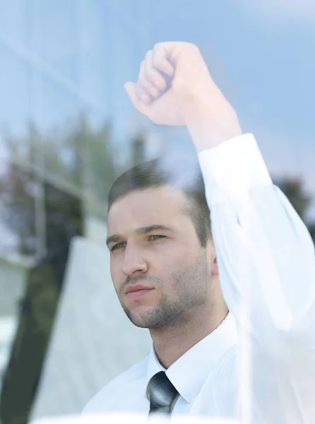 Kilátás mögül üveg.magabiztos üzletember néz ki az ablakon az irodája — Stock Fotó
