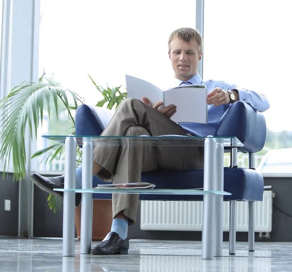 Zakenman leest tijdschrift in wachtkamer — Stockfoto