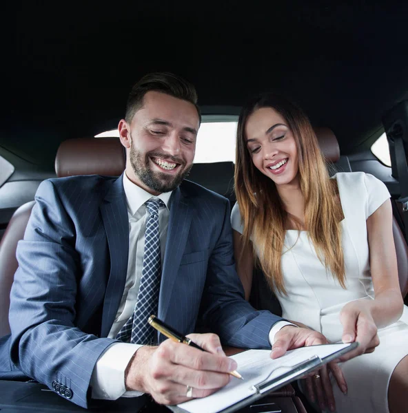 Mooie zakenvrouw werkt met een client in de auto — Stockfoto