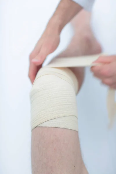 Apropiere. doctor bandajarea piciorului pacientului — Fotografie, imagine de stoc