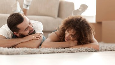 Yeni bir daire arka plan halıya yatan genç Çift