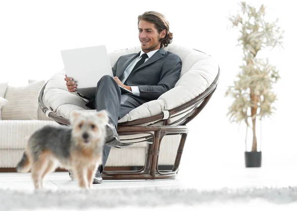 Modern businessman with laptop sitting in living room. — Stock Photo, Image