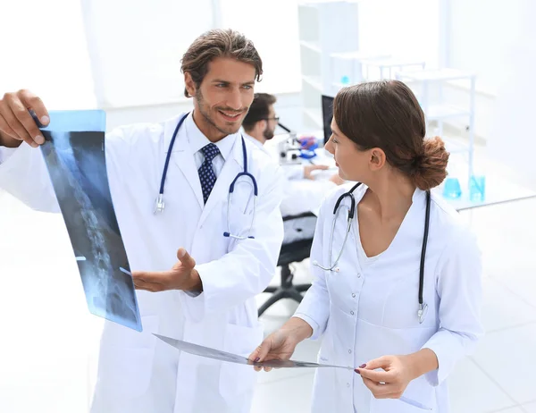 Cirujano masculino con enfermera examinando informe de rayos X — Foto de Stock