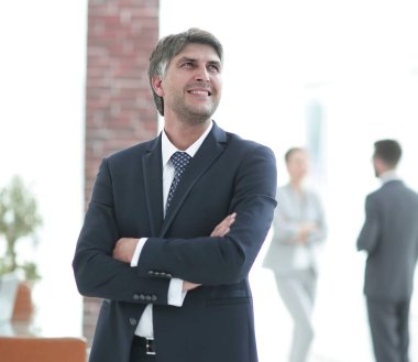 Kollarını kavuşturmuş çekici bir iş adamının fotoğrafı.