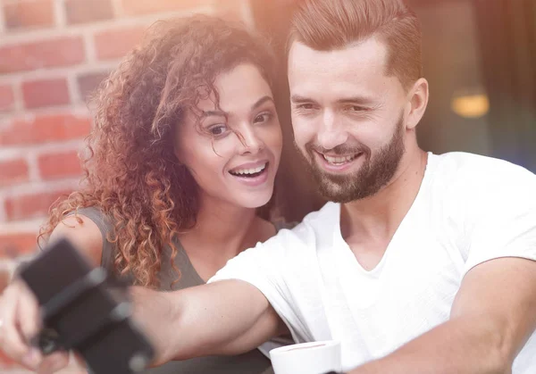 Fröhliches Paar setzt sich in ein Café und macht ein Selfie — Stockfoto