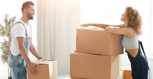 молодая пара распаковывает коробки в новом доме
