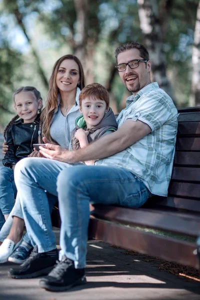 Zittend op bankje in Park zomer en gelukkige familie — Stockfoto