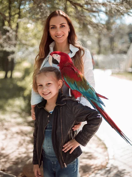 Portret van de moeder en dochter met Ara papegaai — Stockfoto