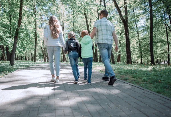 Rear view.modern family on a walk in the Park. — Stock Photo, Image