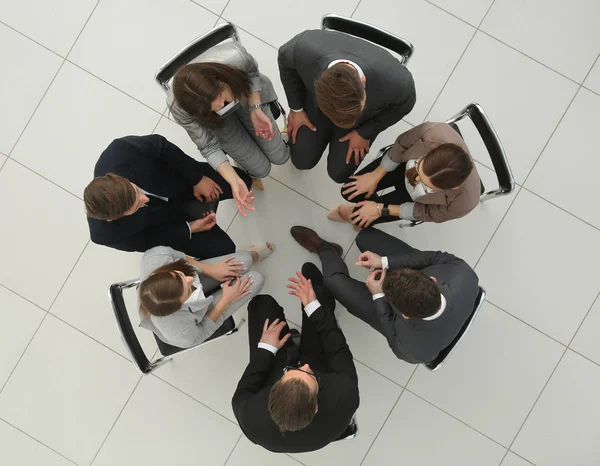 Top view.un grupo de empleados sentados en un círculo — Foto de Stock