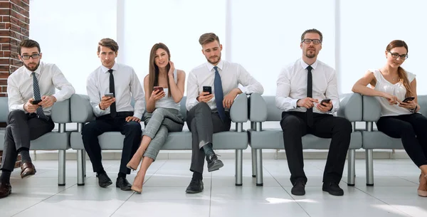 Grupp unga anställda sitter i rad i office väntrummet — Stockfoto