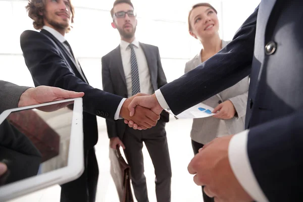 Os funcionários olham para os parceiros de negócios handshake — Fotografia de Stock
