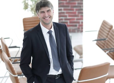 Bir boş toplantı odasında duran iş adamı