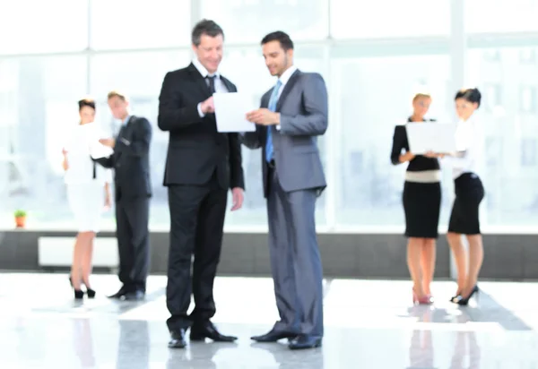 Business background.blurred image of business people standing in office. — Stock Photo, Image