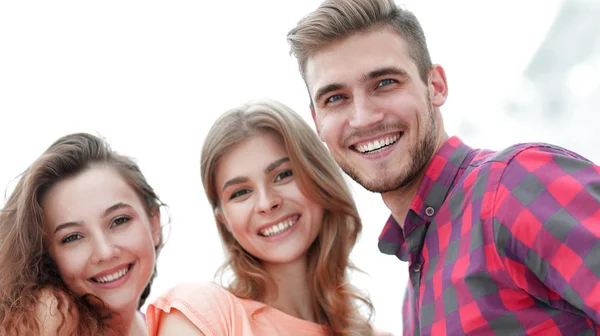 Close-up de três jovens sorrindo em fundo branco — Fotografia de Stock