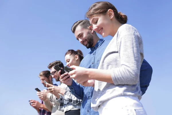 Les jeunes utilisant des smartphones pour rechercher un réseau — Photo