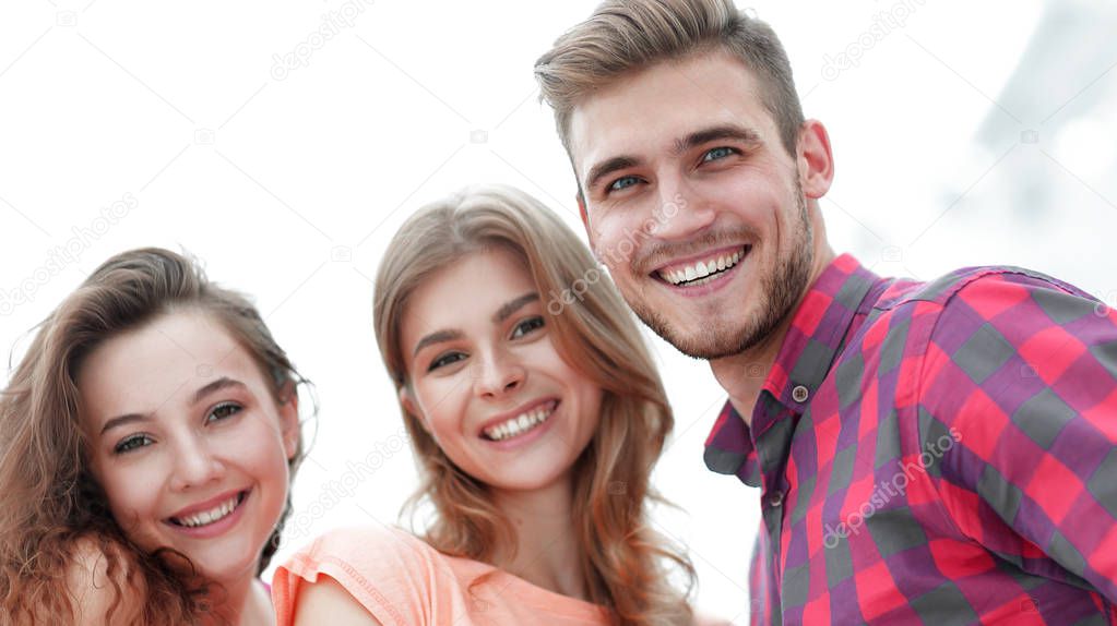 closeup of three young people smiling on white background