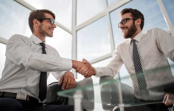 Handshake ludzi biznesu, siedząc w holu centrum biznesowe — Zdjęcie stockowe