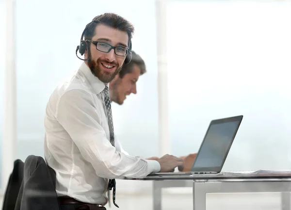 Business man in headphones sitting at his Desk — Stock Photo, Image