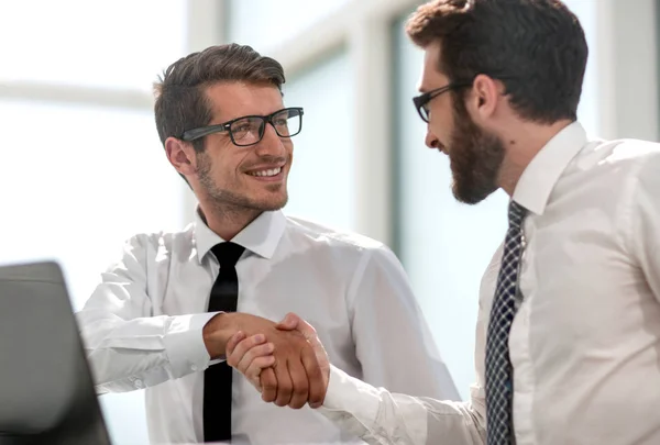 Handshake affärskollegor sitter vid sina skrivbord — Stockfoto