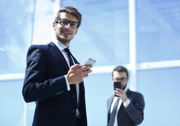 Moderna affärsman med en smartphone på bakgrunden office — Stockfoto