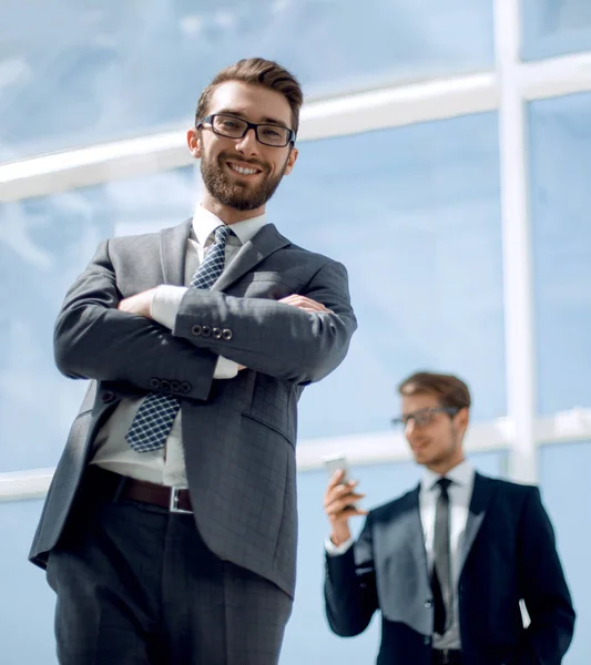 Uśmiechający się biznesmen na tle nowoczesnego biura — Zdjęcie stockowe