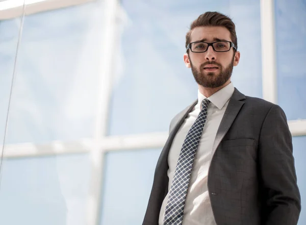 Giovane uomo d'affari in piedi vicino alla finestra dell'ufficio — Foto Stock