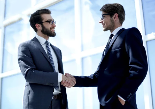 Handshake business partners i ett ljust kontor Stockbild