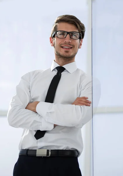 Fechar up.confident empresário de pé perto da janela do escritório — Fotografia de Stock