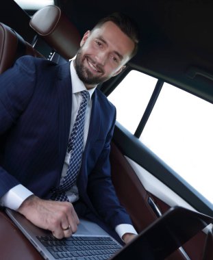 başarılı adam arabanın içinde otururken dizüstü bilgisayar ile çalışma