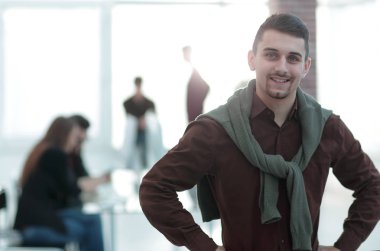 Kendine güvenen genç adam ofis arka planda.