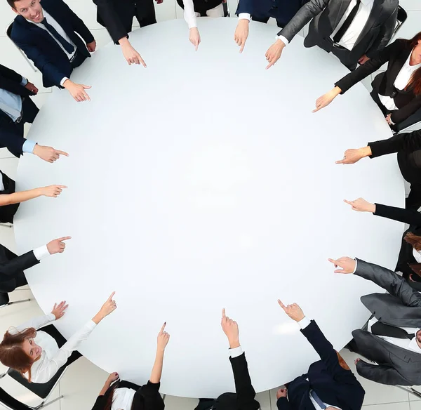 Close up .business team pointing in the center of the table . — стоковое фото