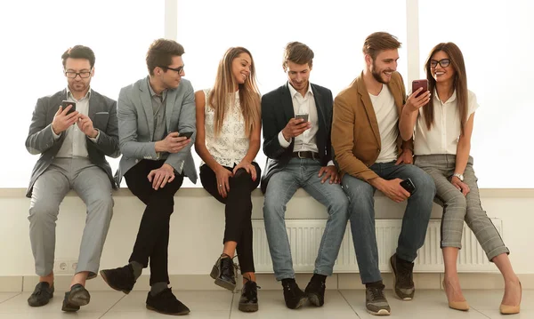 Enquanto espera pela entrevista, um grupo de jovens usa gadgets — Fotografia de Stock