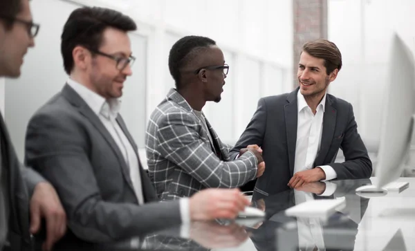 Stretta di mano di giovani partner commerciali al tavolo dell'ufficio — Foto Stock