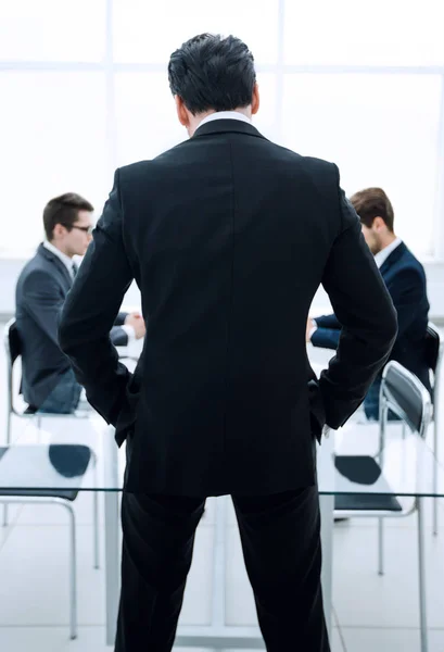 Achterste view.businessman staande in de vergaderruimte — Stockfoto