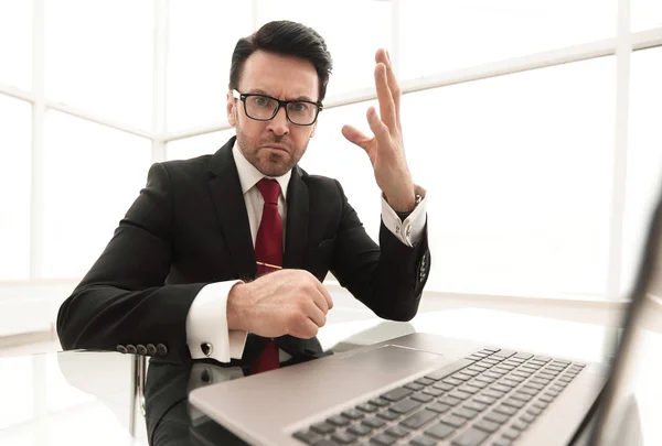 Controle van de ernstige zakenman rekeningen zittend op zijn Bureau — Stockfoto