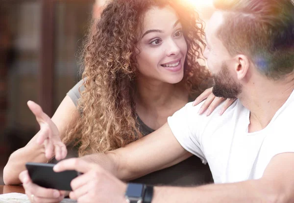 Happy älskande par som med en smartphone som sitter i terrass — Stockfoto