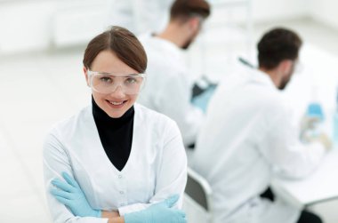 Laboratuvar arka planda bilim adamı portresi.