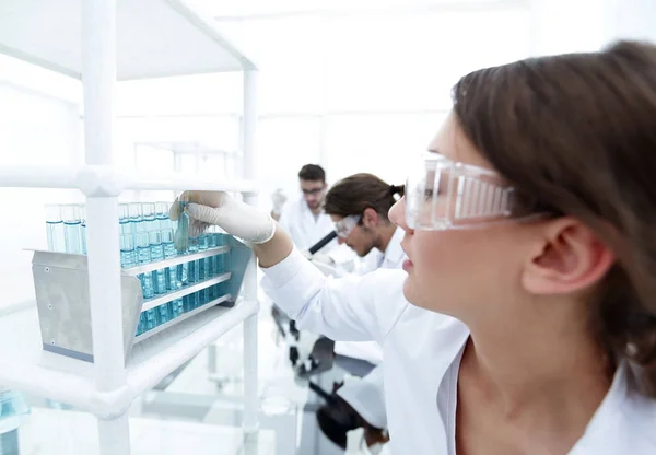 Giovane donna con provette in laboratorio — Foto Stock